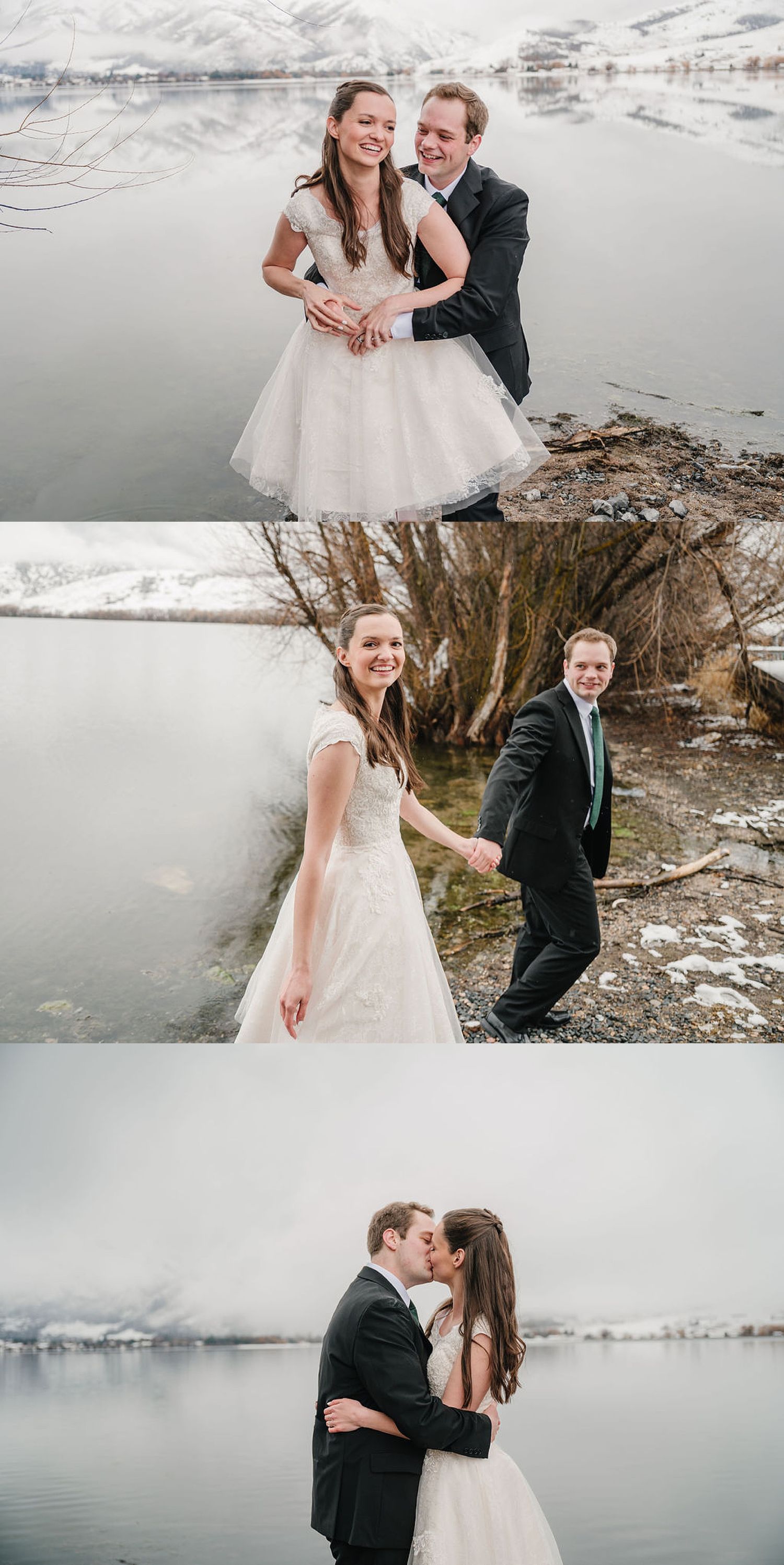 A couple in wedding attire embraces next to a serene winter lake with snow-capped mountains in the background.