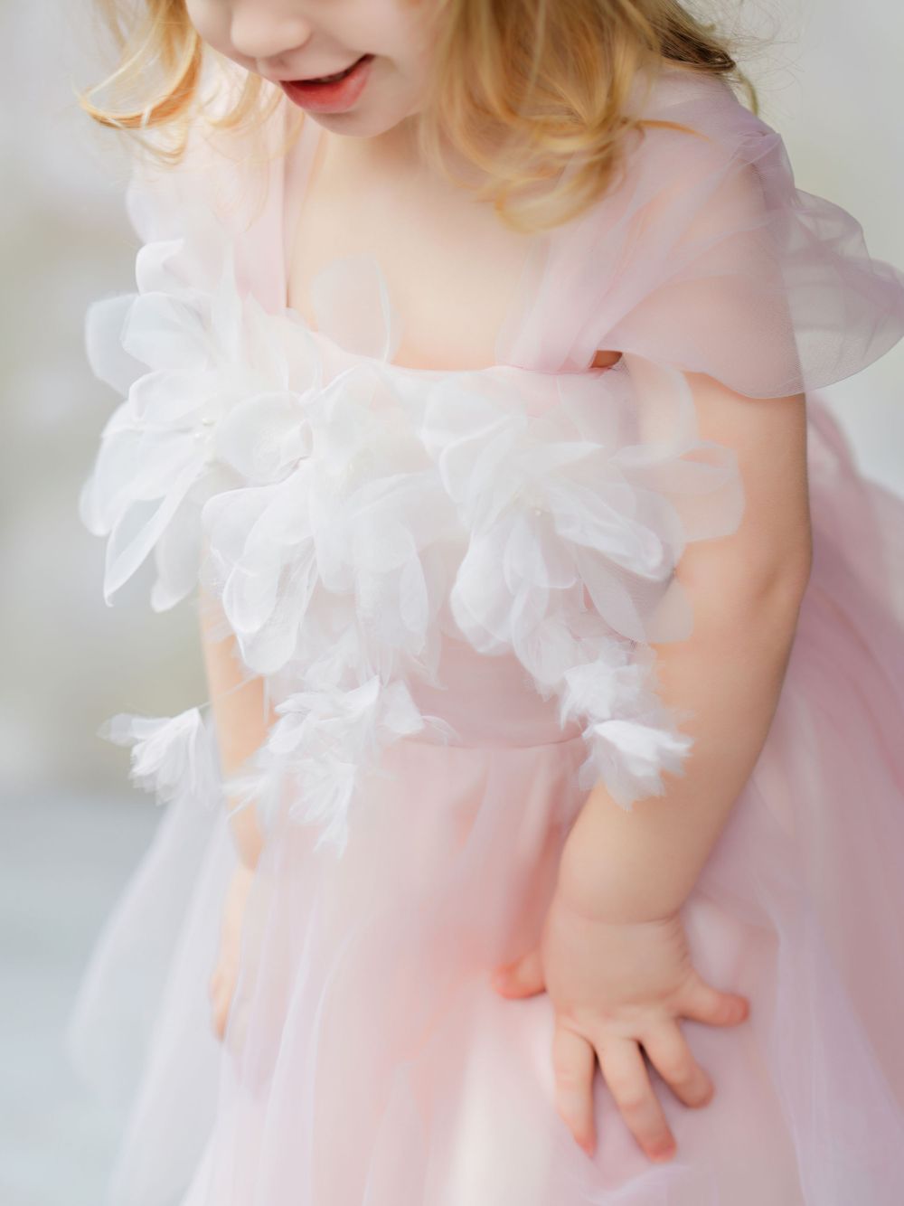 Ethereal pink and white tulle dress with delicate ruffles shown in soft dreamy light in Bellevue studio.