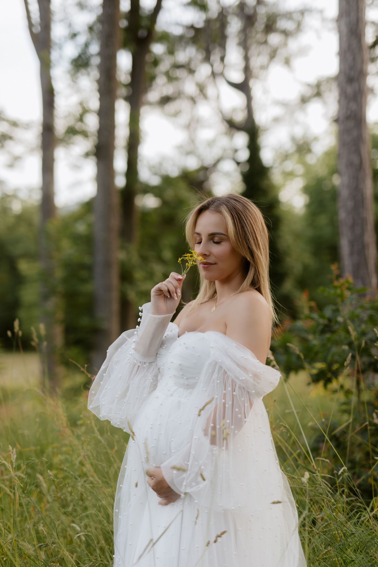 Ethereal outdoor portraits in white lace dress among tall pine trees.