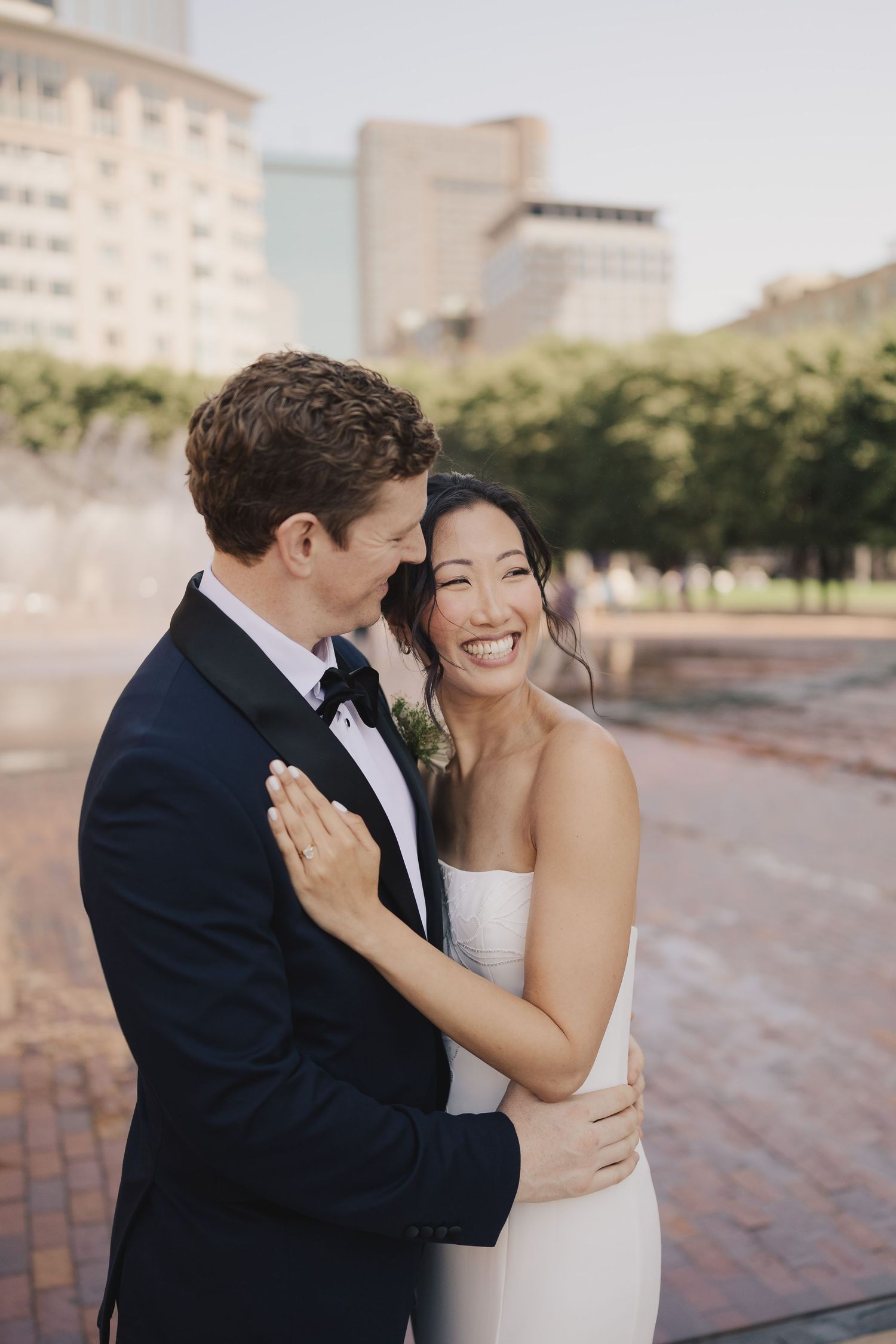 Outdoor wedding ceremony against mountain backdrop with white floral arch and seated guests.