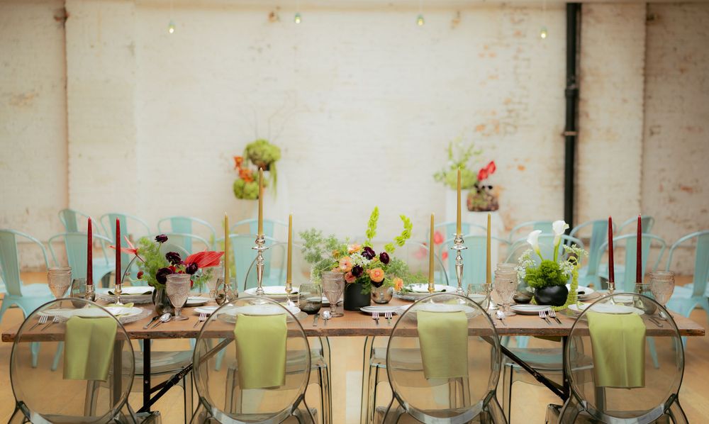 Elegant wedding reception table setting with mint green accents, glass vases, and delicate floral centerpieces.