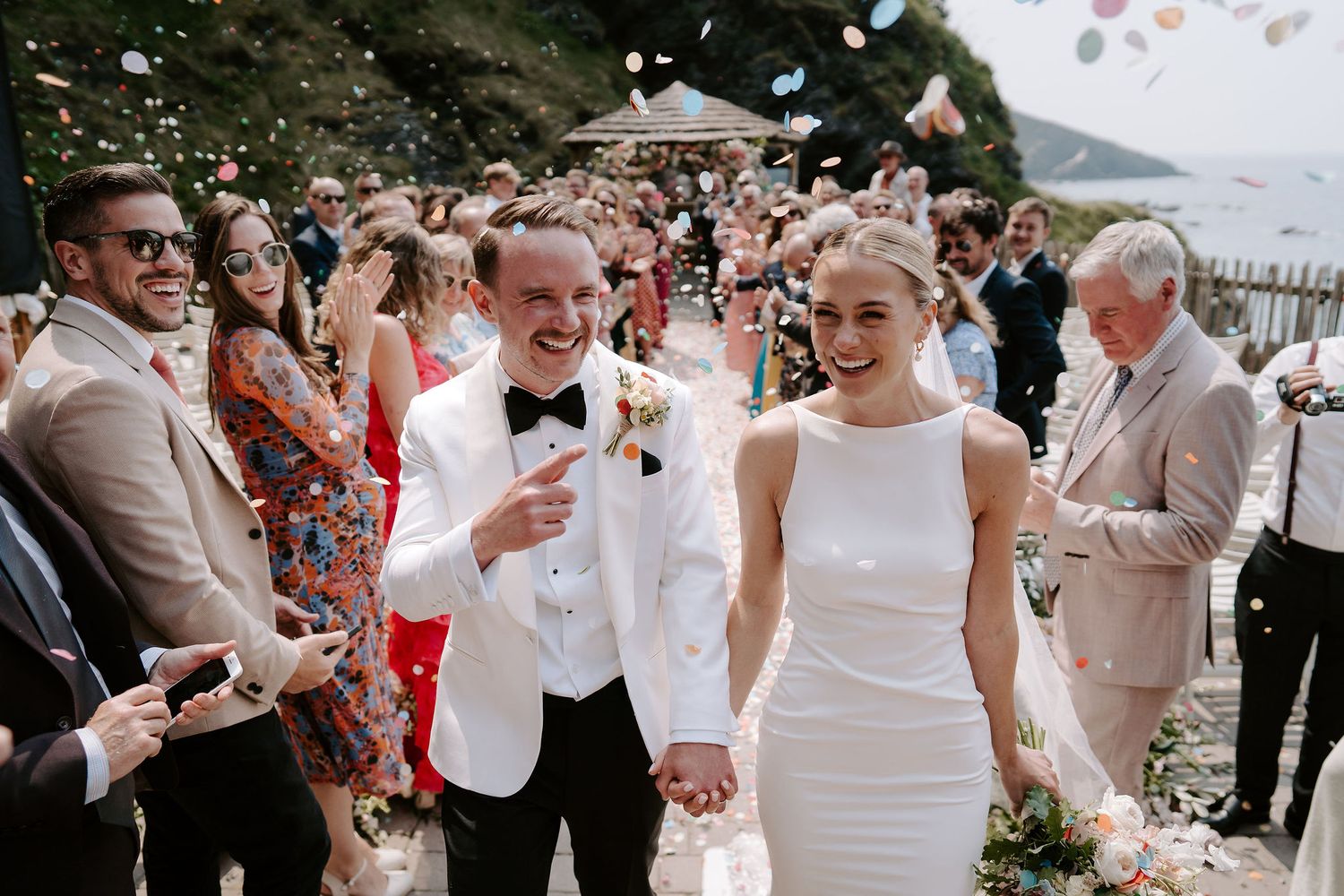 Bride and groom confetti throw at tunnels beach wedding venue in north Devon