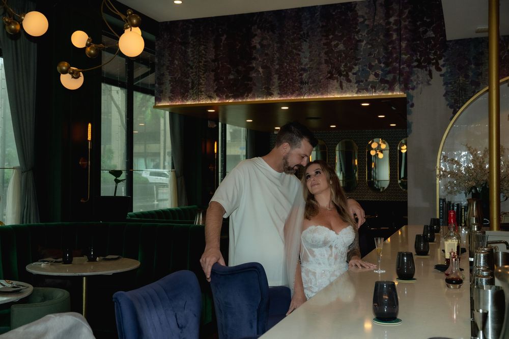Wedding couple at the bar posing and looking at each other.