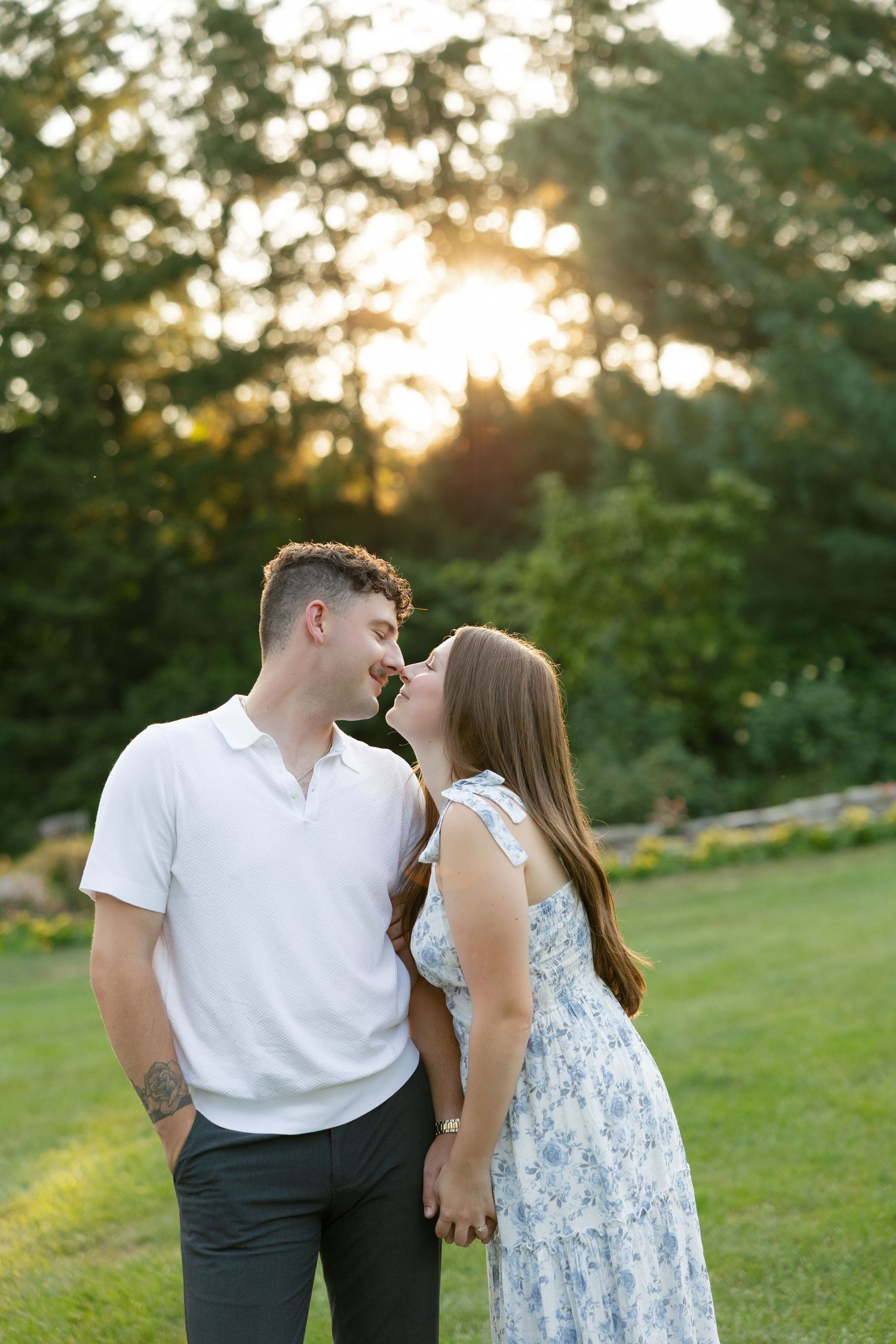 Romantic couple about to kiss at sunset in a beautiful green garden park.