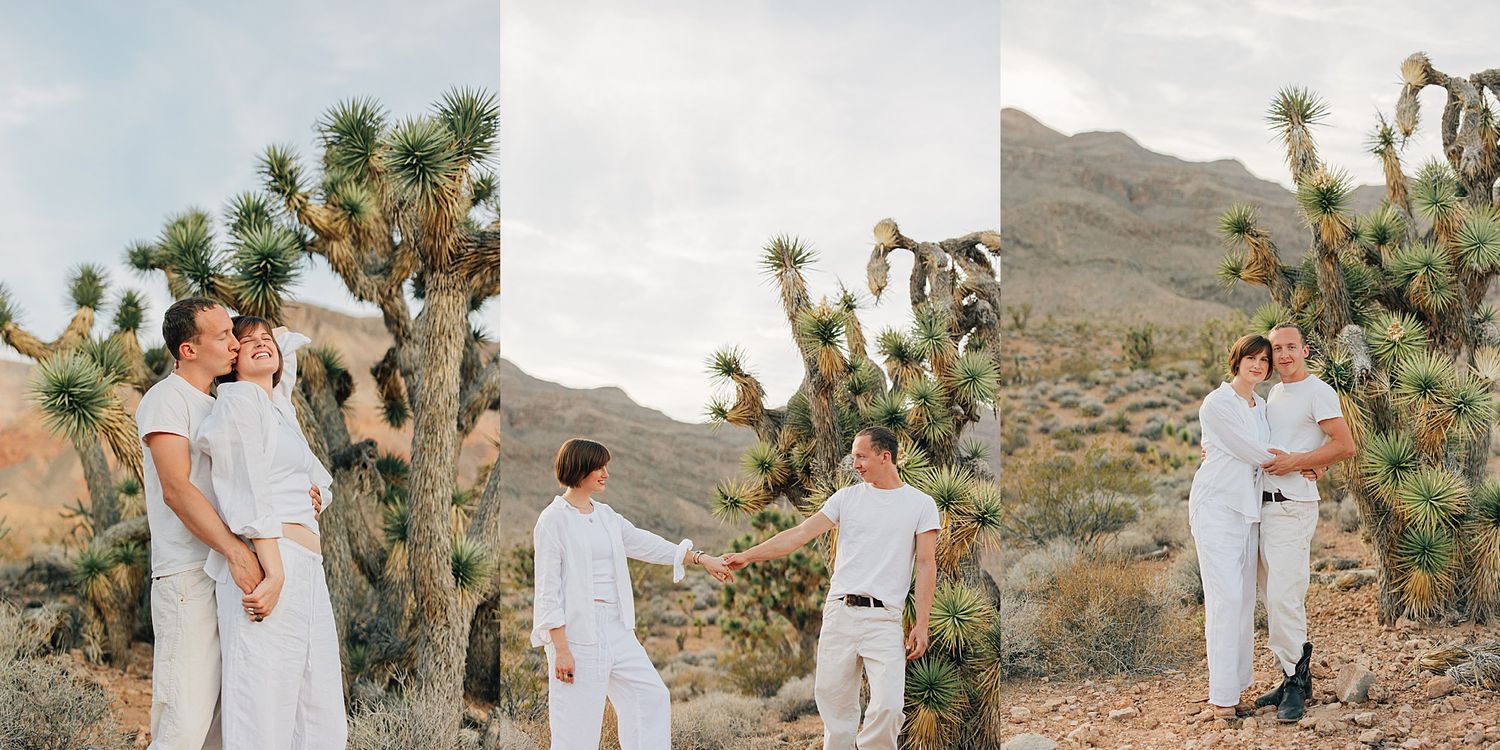 Couple in white outfits sharing a romantic moment near Joshua trees in a desert landscape.