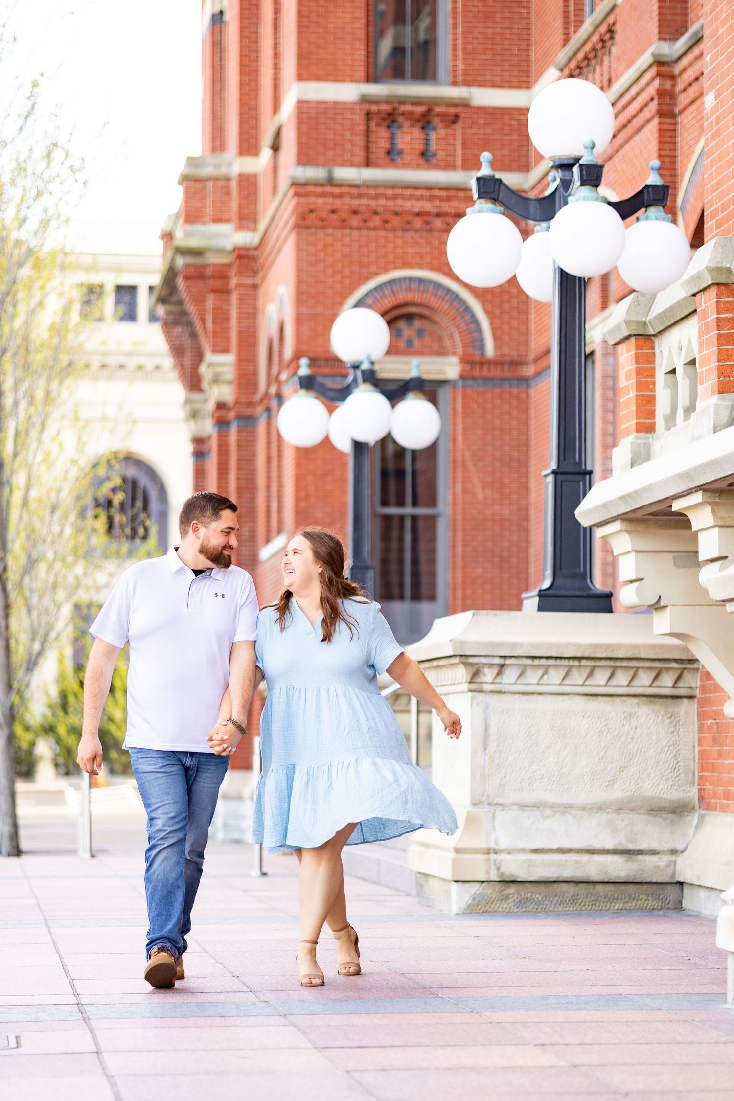 Couplewalking in front of Cincinnati Music Hall's stunning red brick Victorian Gothic architecture.