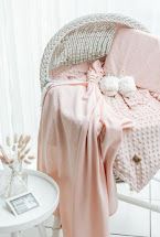 Baby wrapped in pink floral rose print blanket with white sherpa trim.
