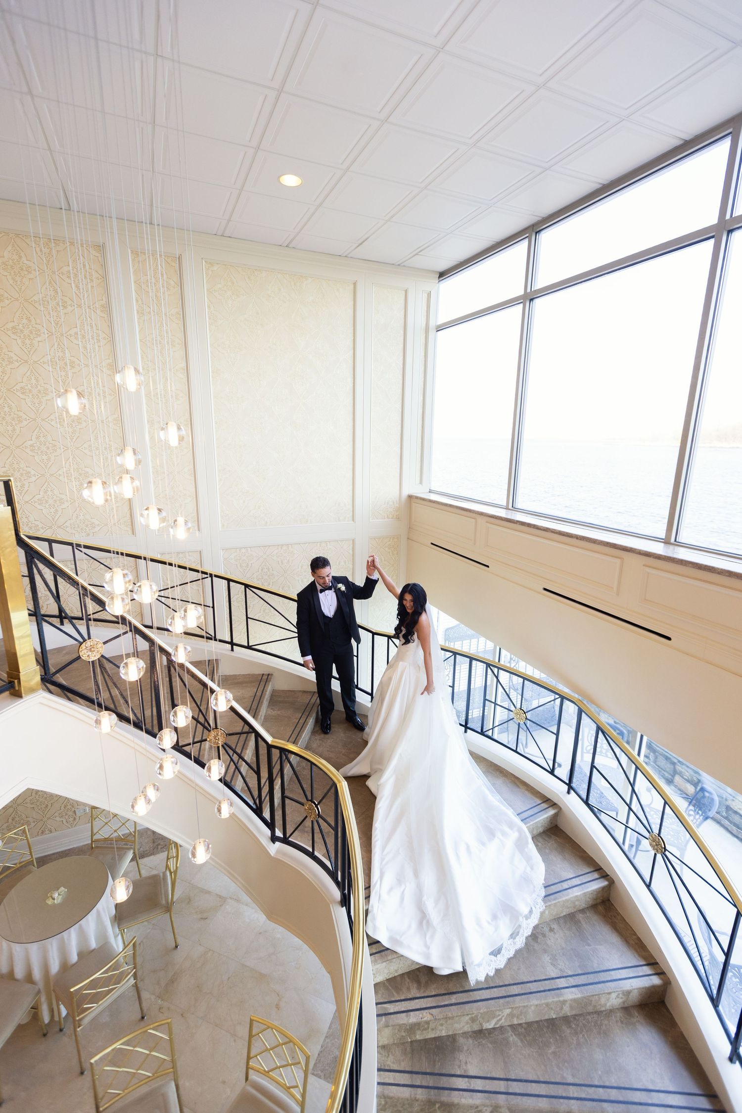Bride and groom on the iconic staircase at Glen Island Harbour Club overlooking Long Island Sound.