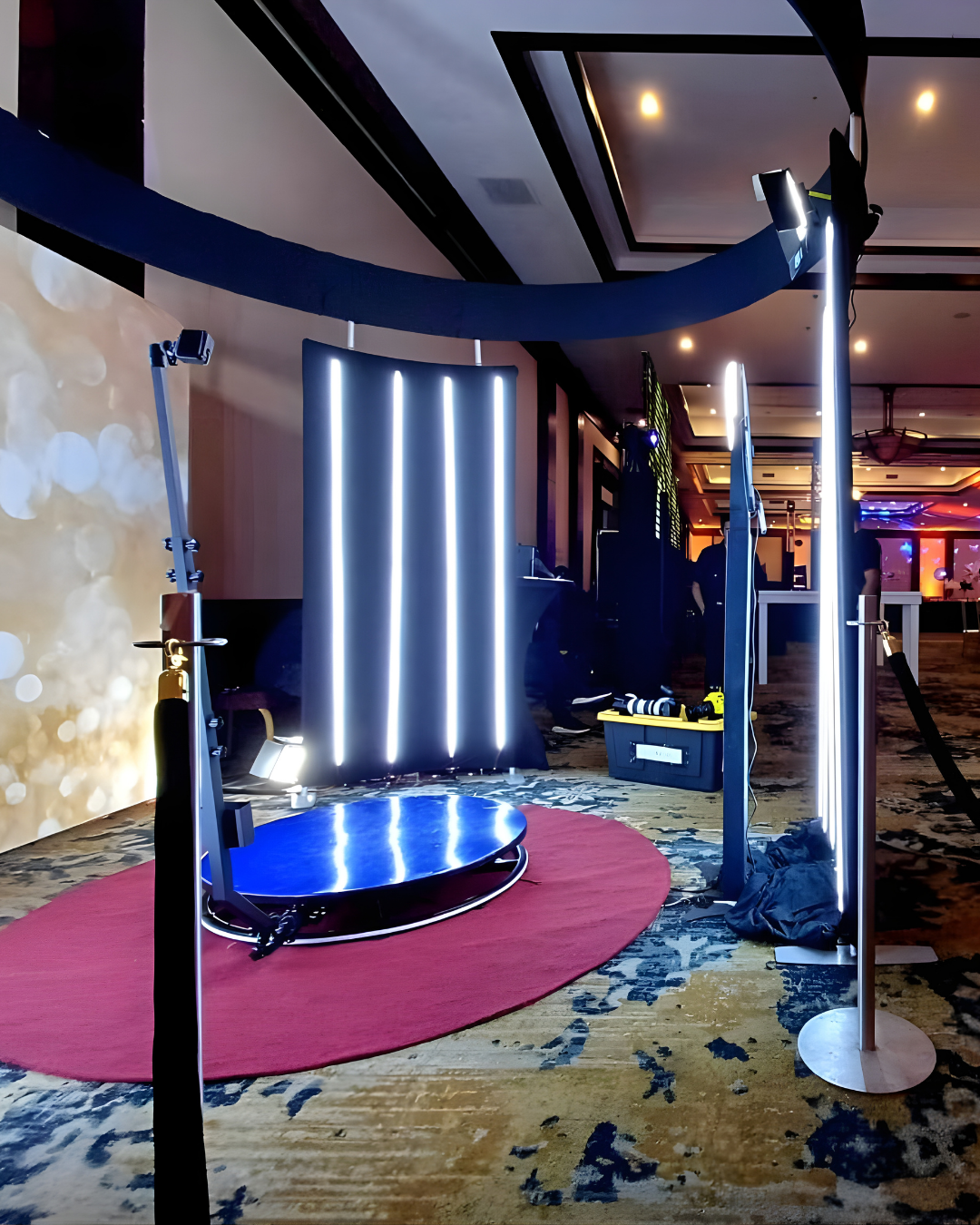 Modern interior hallway with curved design featuring blue LED lighting, pink carpet, and geometric patterned flooring.