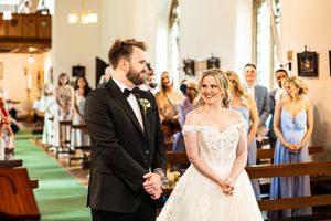 Bride and groom exchange vows at church altar during wedding ceremony.