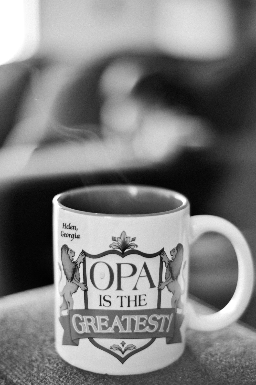 Black and white photograph of a coffee mug with decorative text design reading 'OPAL IS THE GREATEST'.