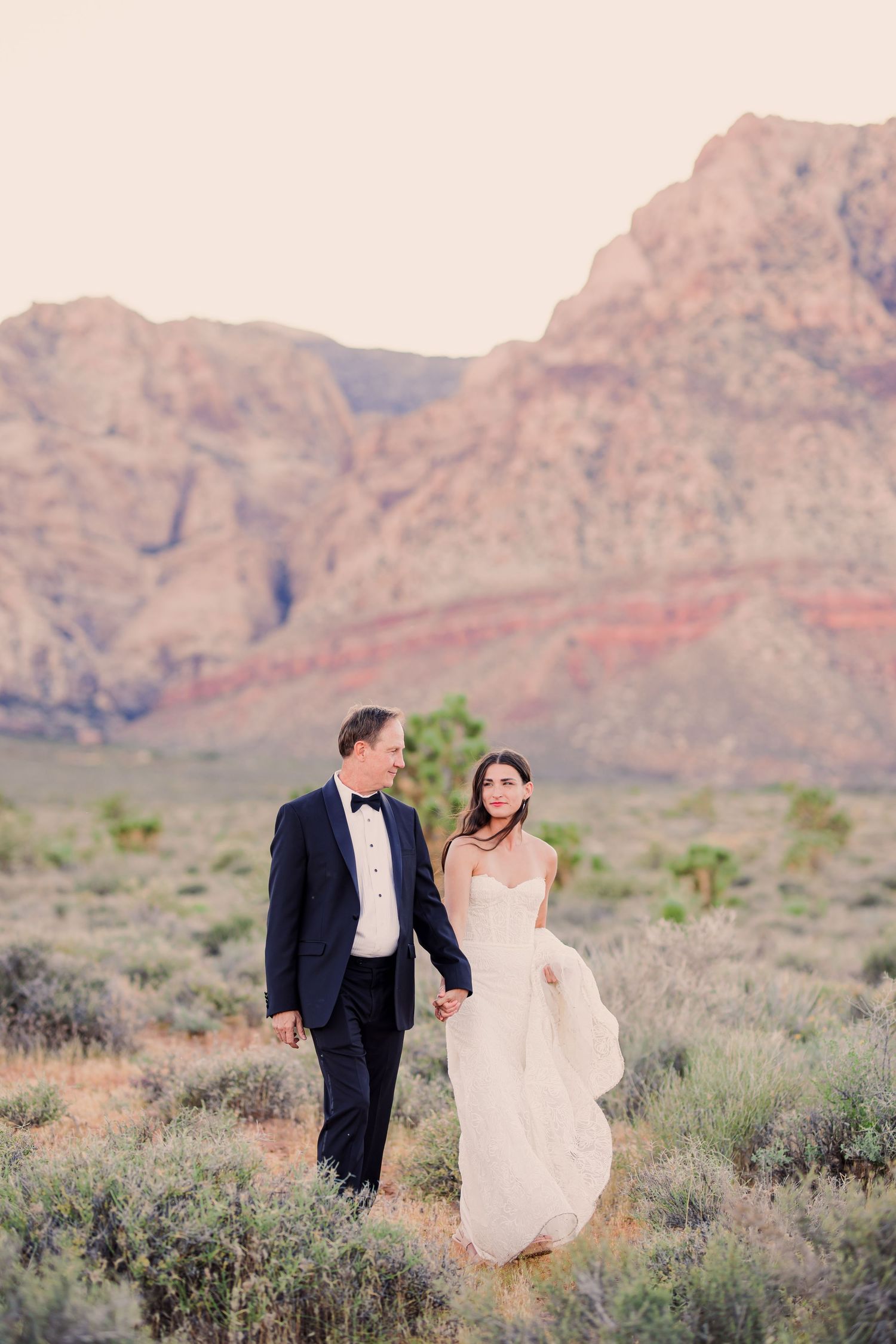 Black and white wedding photos showing a bride in a flowing white dress with a long veil in an elegant hallway setting.