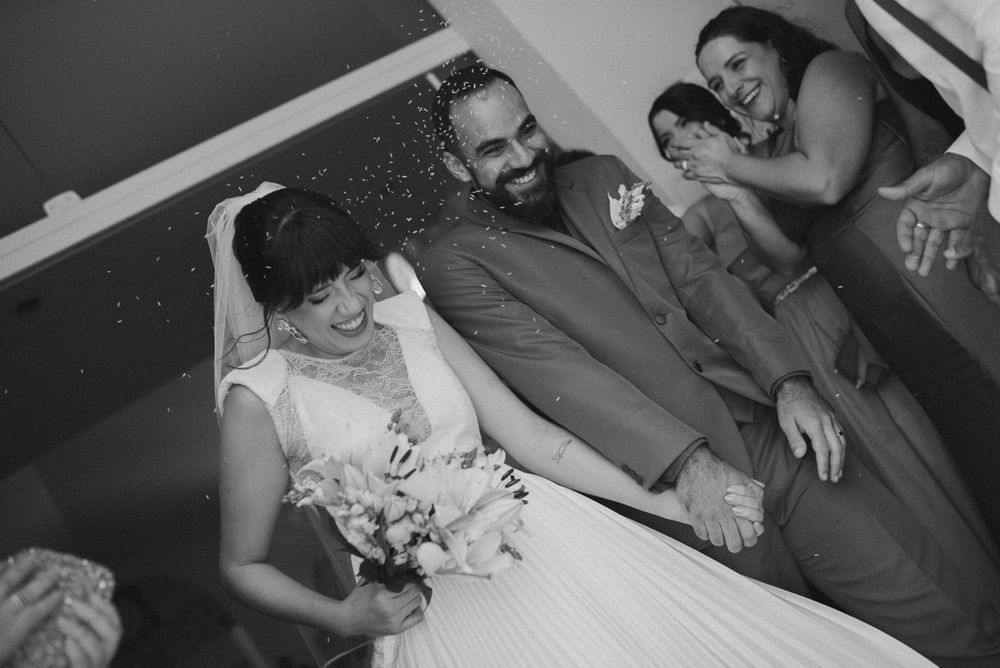 A black and white photo series showing candid moments from a wedding celebration with guests and dancing.