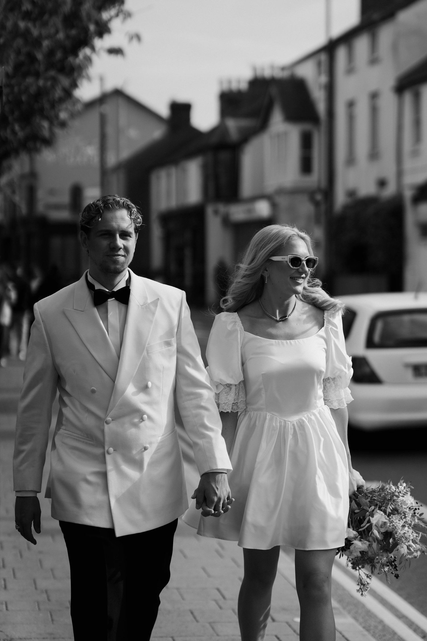 bride and groom walking through Oxford streets