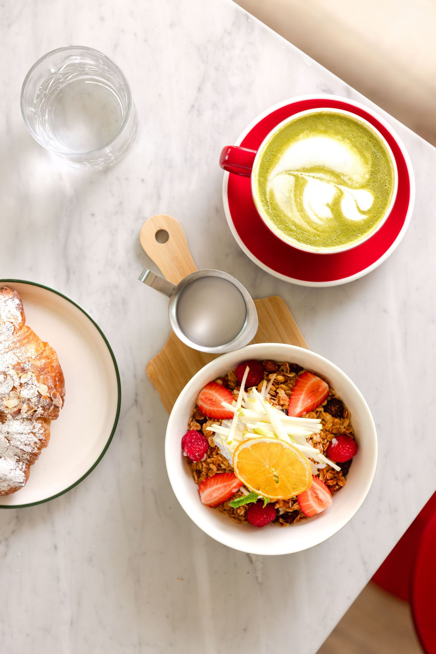 Breakfast spread: almond croissant, matcha latte, muesli bowl. Harvest, Midway