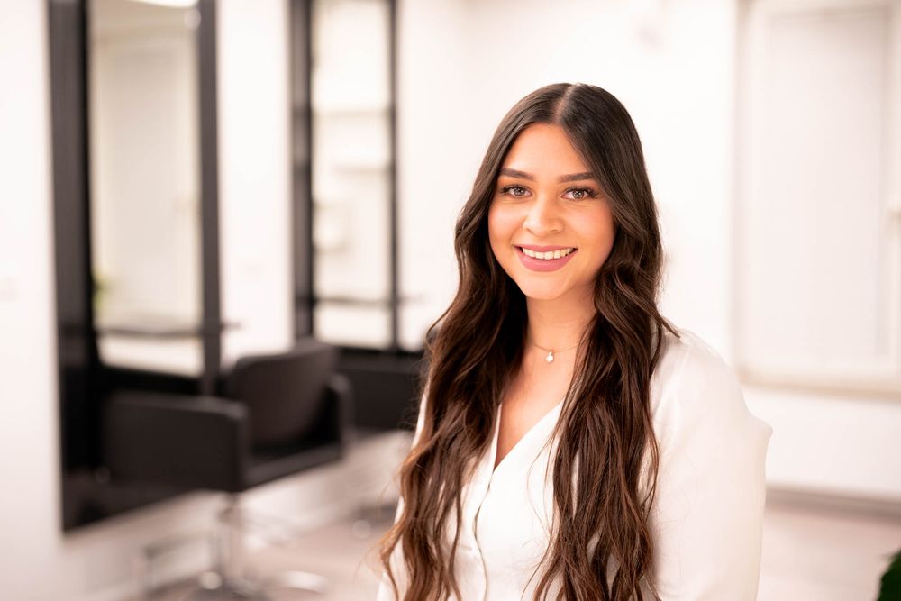 Professional portrait session in a bright modern studio with white walls and black framed artwork.