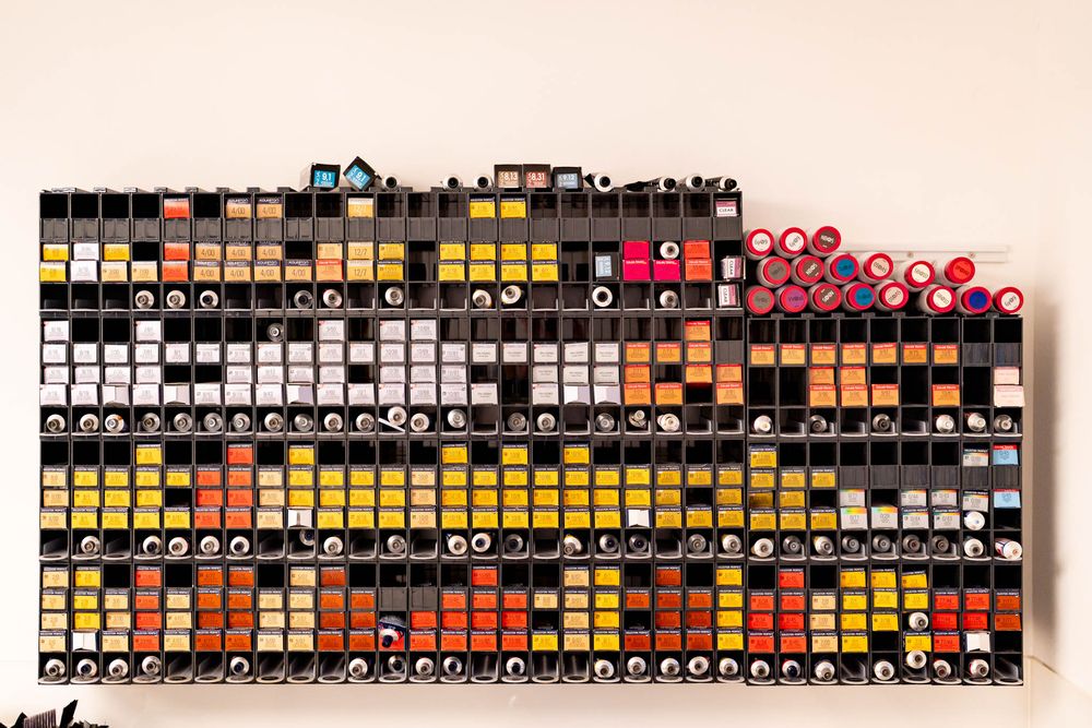 A long row of colorful alcohol markers arranged in a gradient pattern on a white surface.