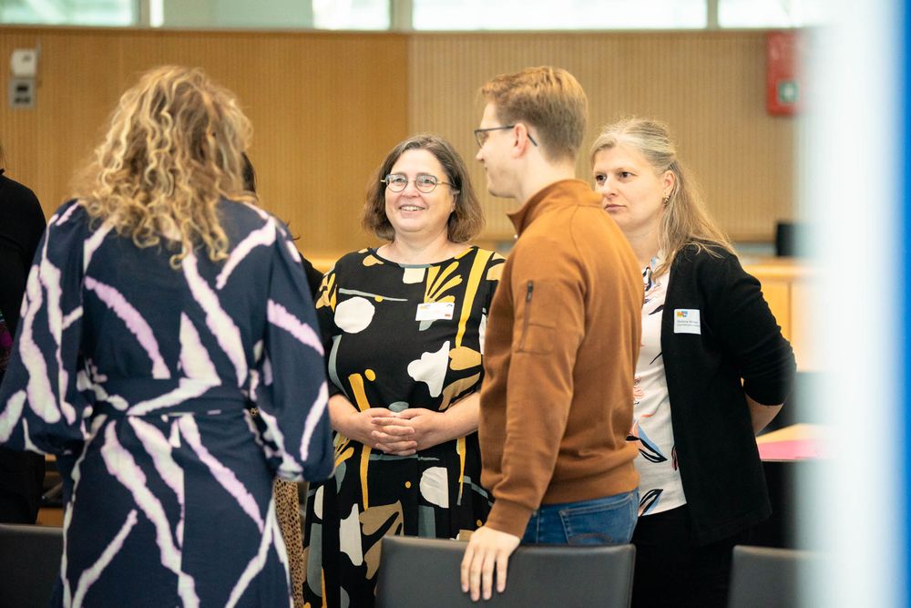 A group of people participate in a sign language class, practicing gestures and movements together.