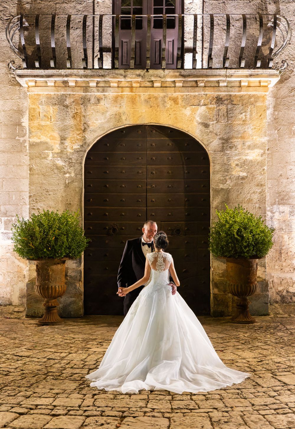 Bride and groom evening shot framed by grand doorway of Italian villa