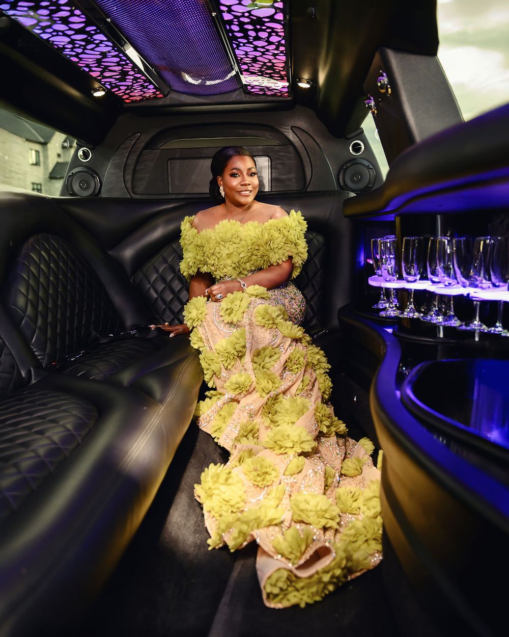 Interior view of luxury limousine with purple ambient lighting and plush black leather seating.