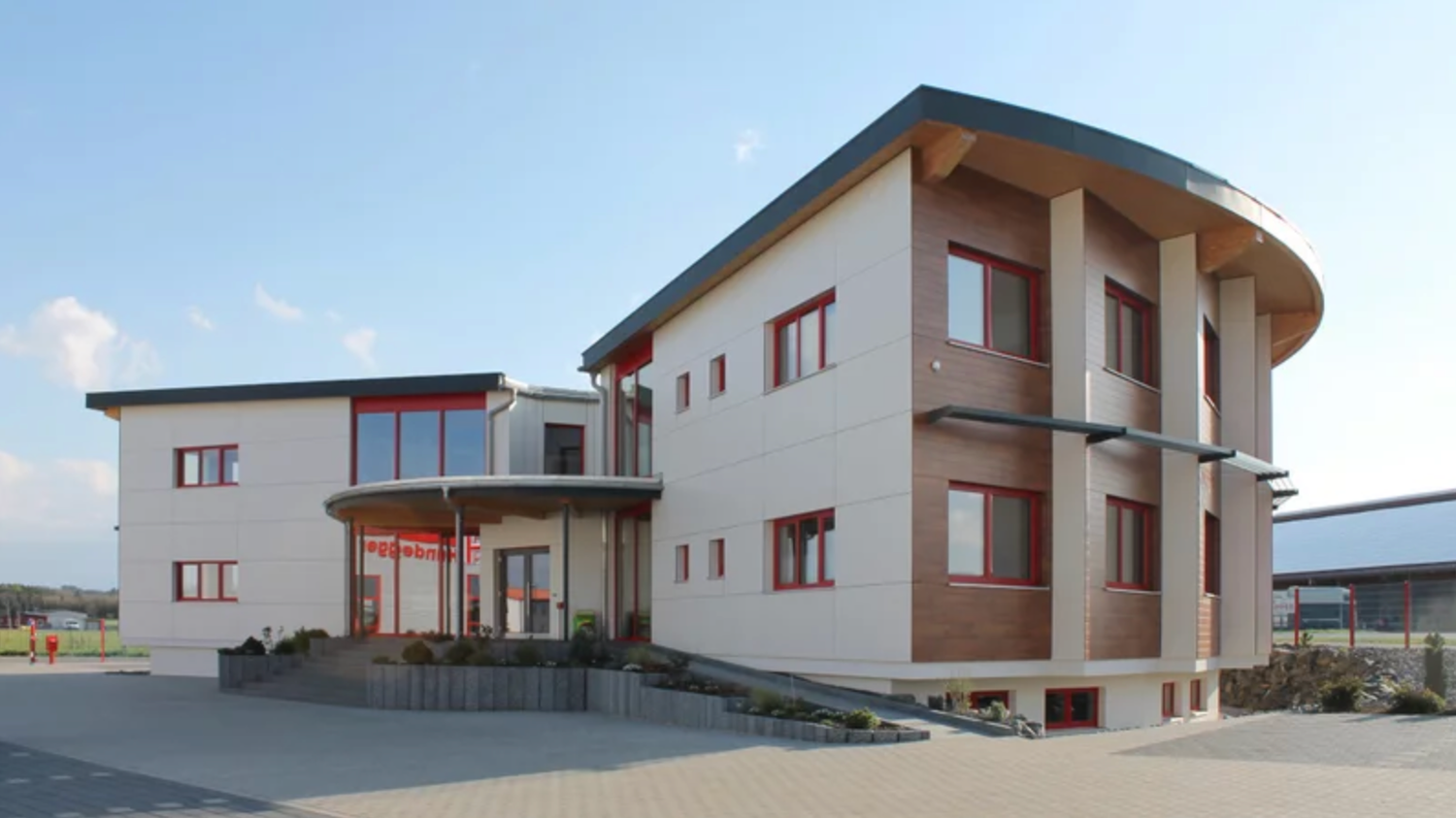 Modern residential complex with beige and brown exterior features multiple connected units on a hillside setting.