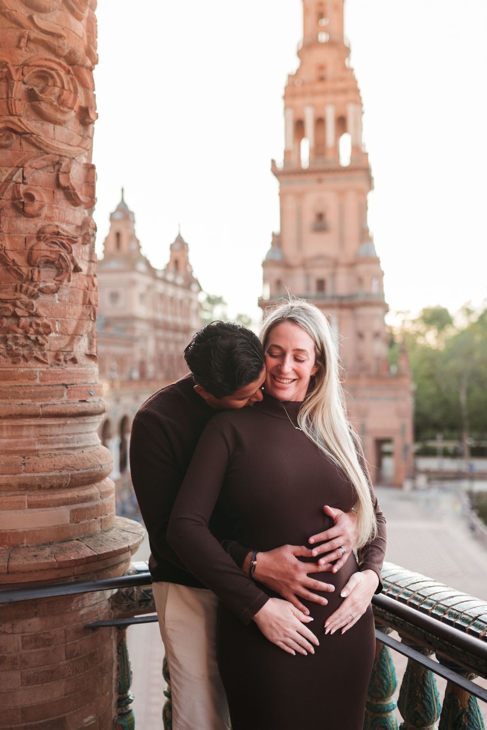Romantic maternity photos captured under ornate architectural columns.