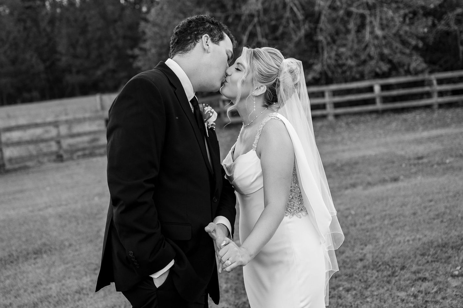 Classic black and white wedding portrait capturing intimate moment outdoors.