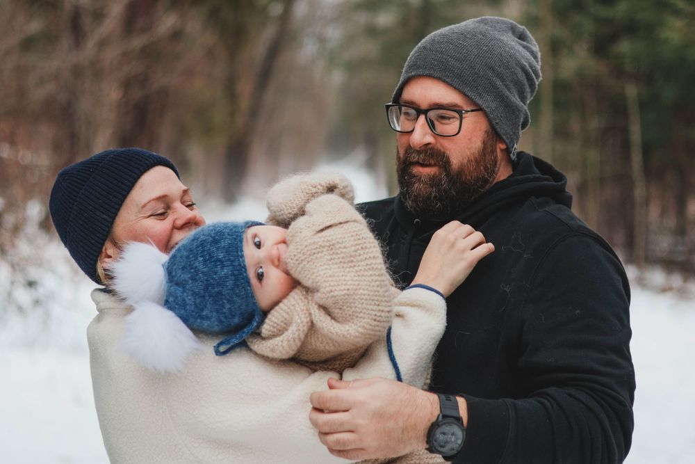 Winter outdoor family portraits showing intimate moments in snowy setting.