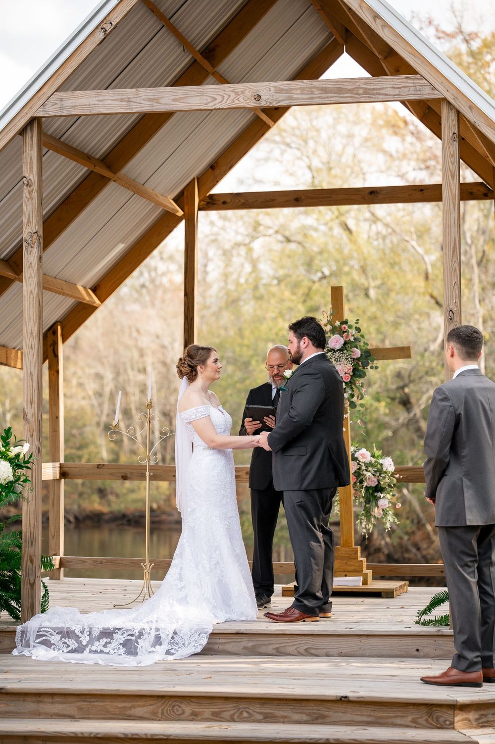 Wedding ceremony sequence under a rustic wooden pavilion with autumn trees in background.