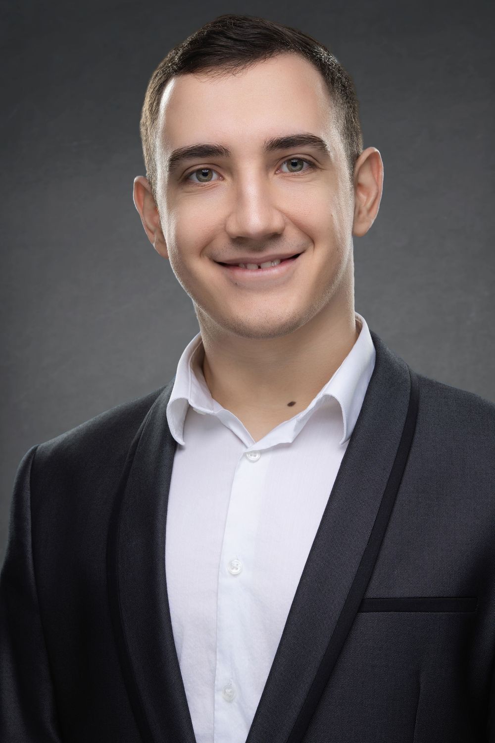 Professional headshot portrait series of person in black suit and white shirt against dark gray background.