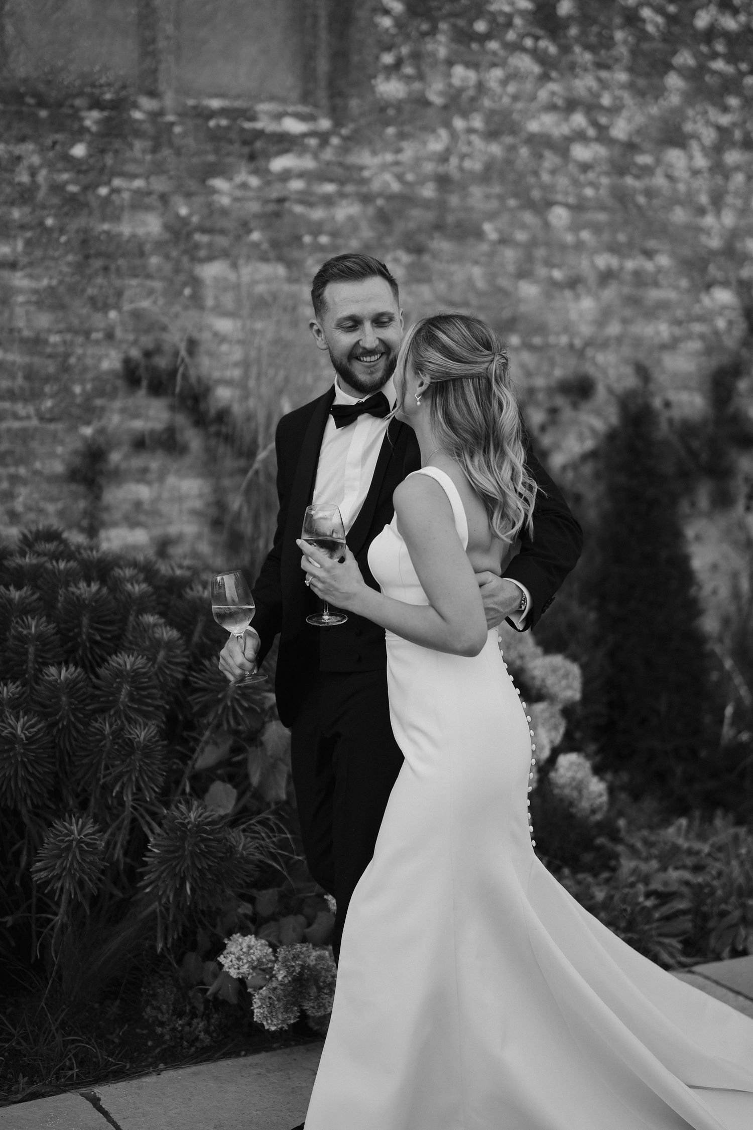 bride and groom walking and smiling at ivy lodge wedding in cirencester