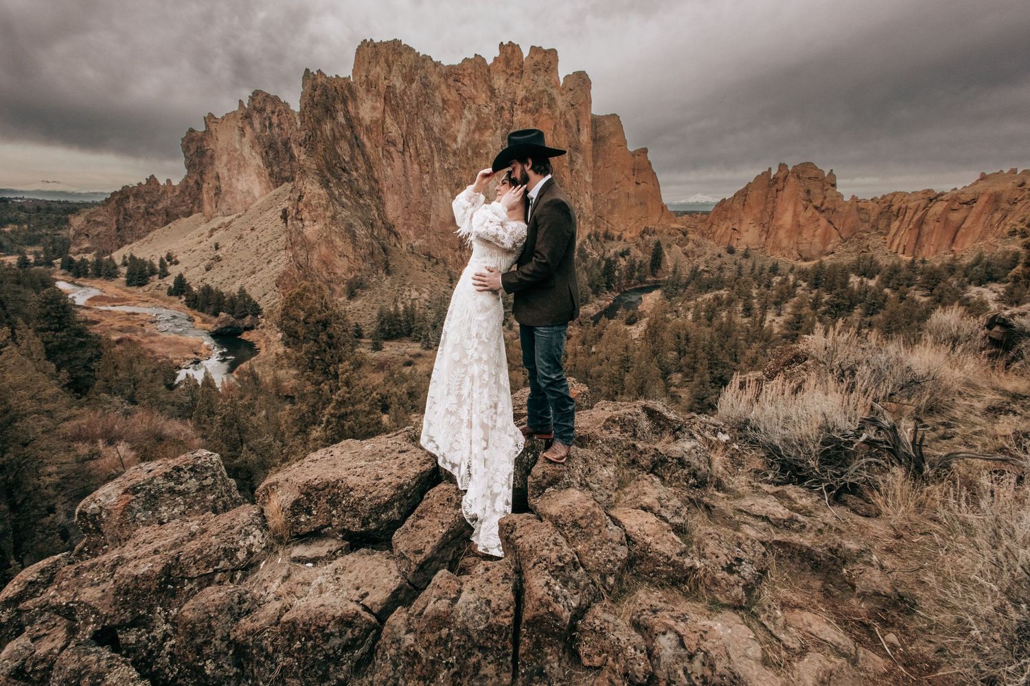 Ellensburg, WA wedding couple kissing in a green field with a cowboy hat in front of them.