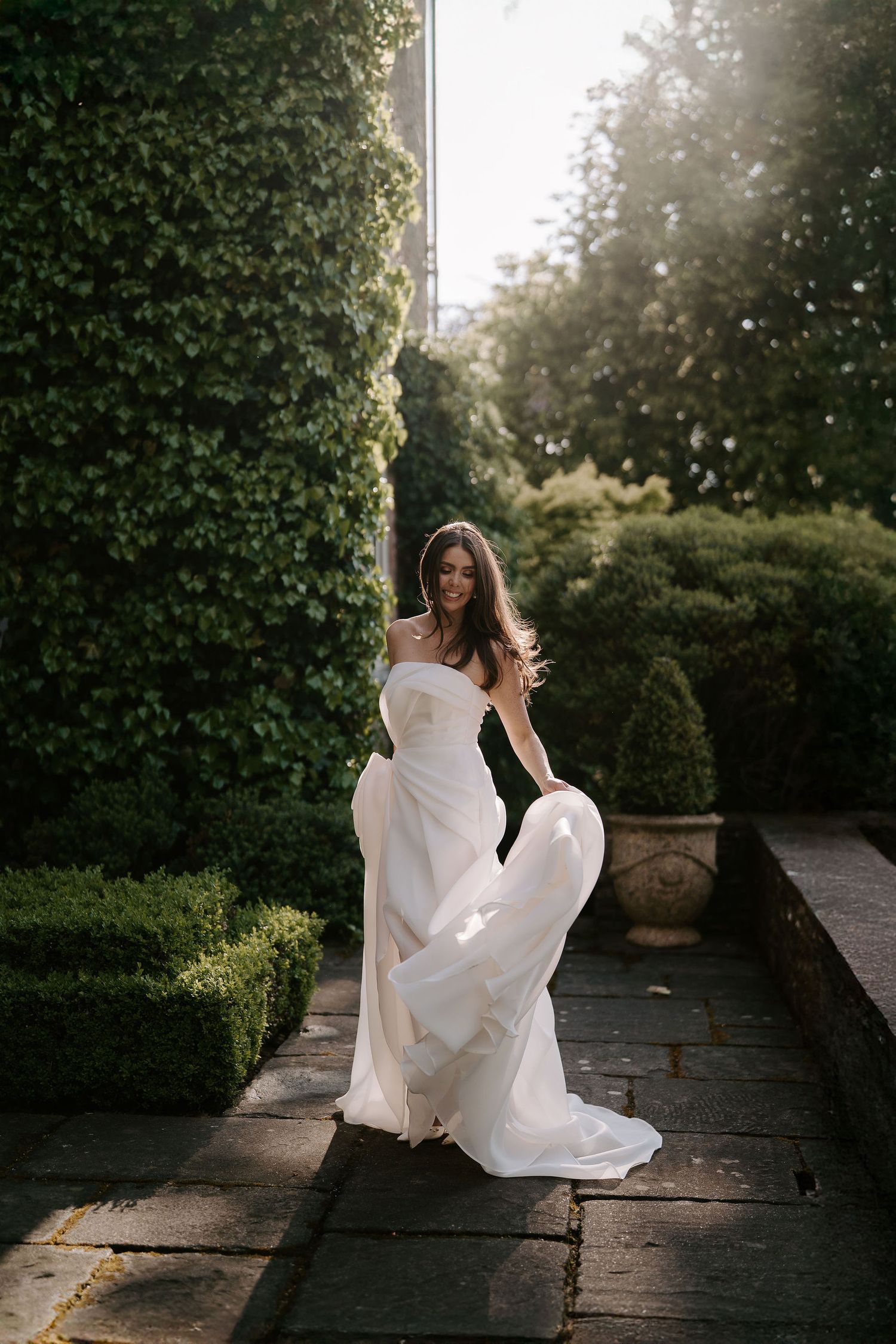 bride twirling her wedding dress in the setting sun at dewsall court in herefordshire