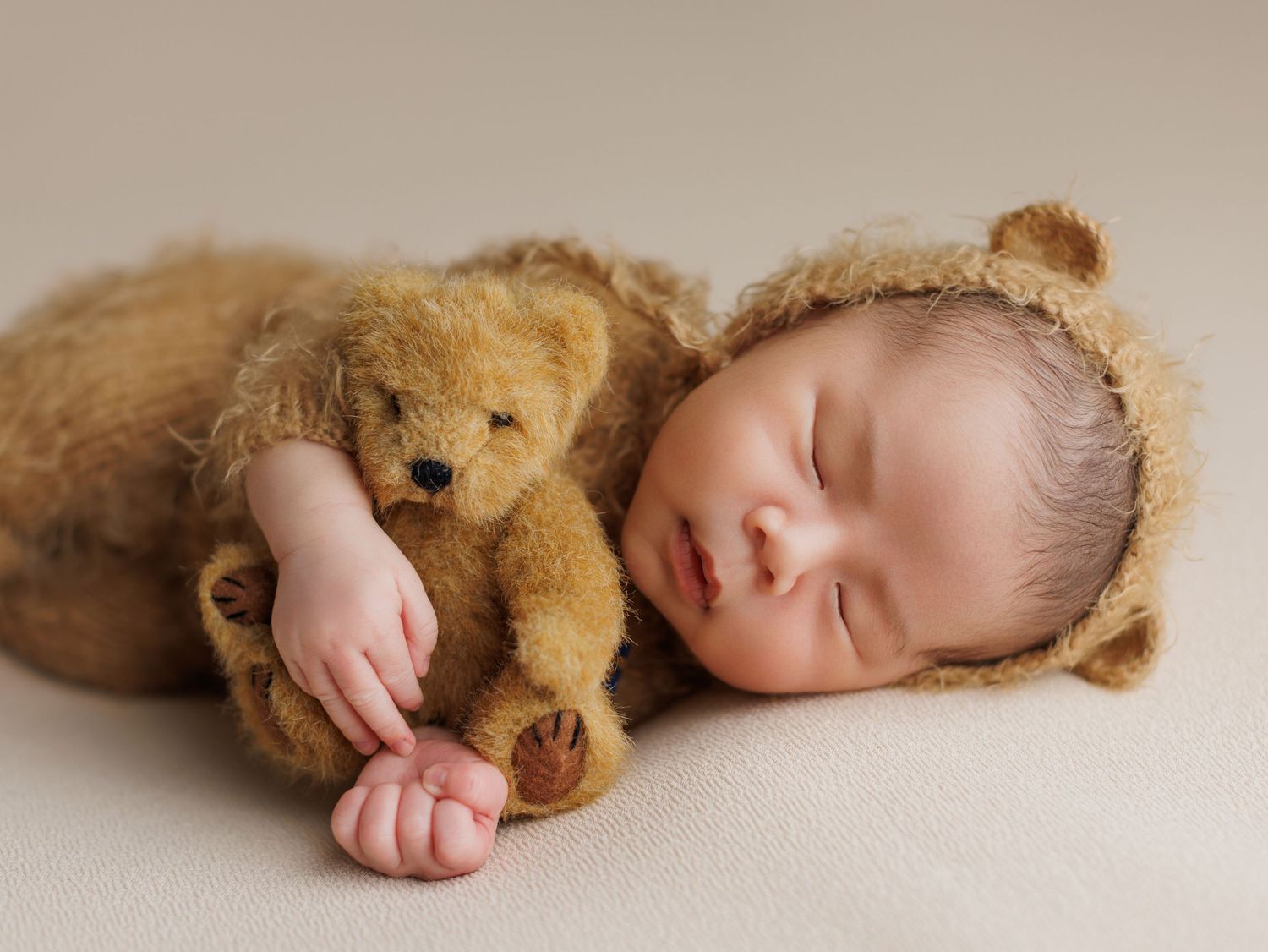 A sleeping baby lies peacefully next to a brown teddy bear in a series of connected photos.