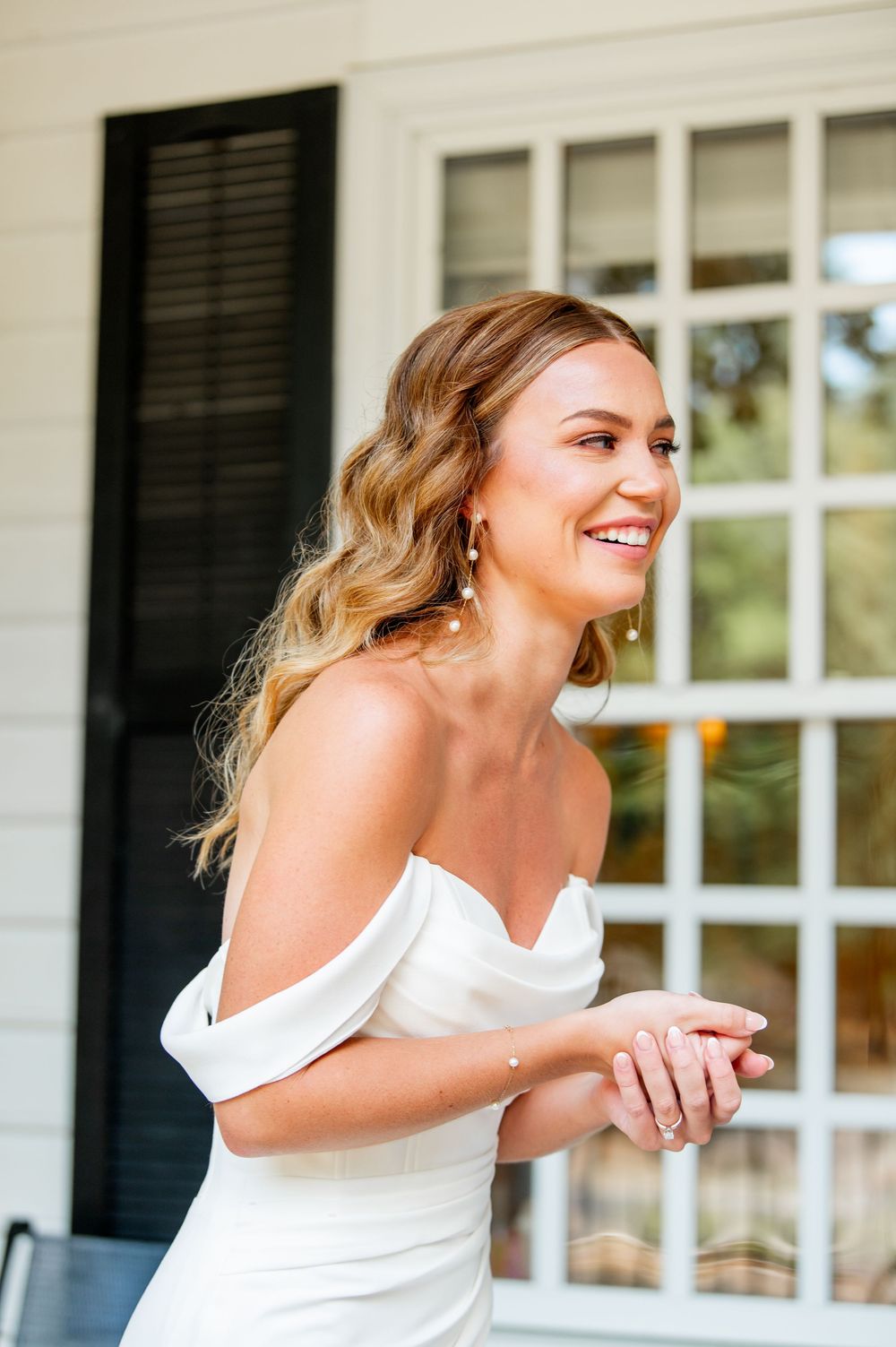 Wedding day portrait on elegant white porch with classic architectural details.