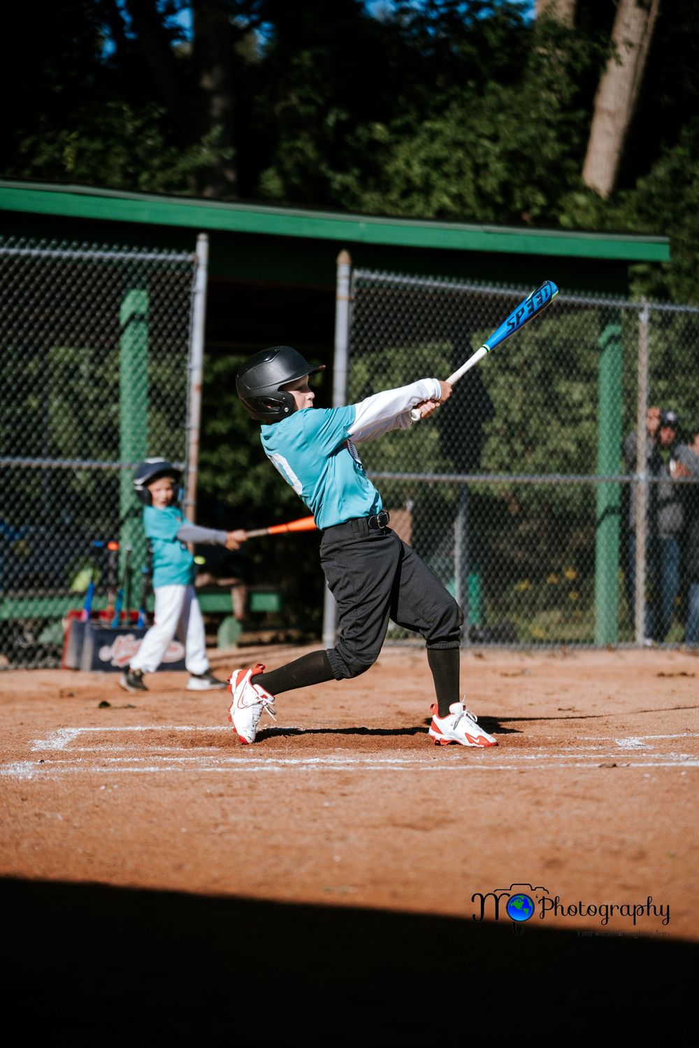 Baseball player executes diving catch on infield dirt during game.
