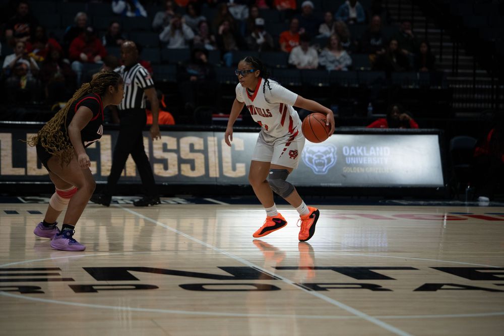 Players dive for a loose basketball during an intense game sequence.