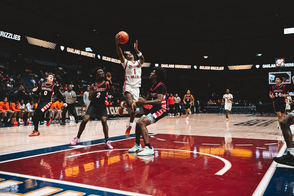 Basketball player leaps for dramatic shot during professional game on illuminated court.