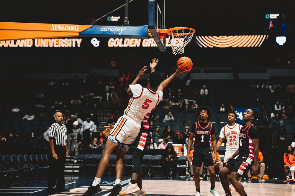 Basketball players compete intensely on the court during a collegiate game.