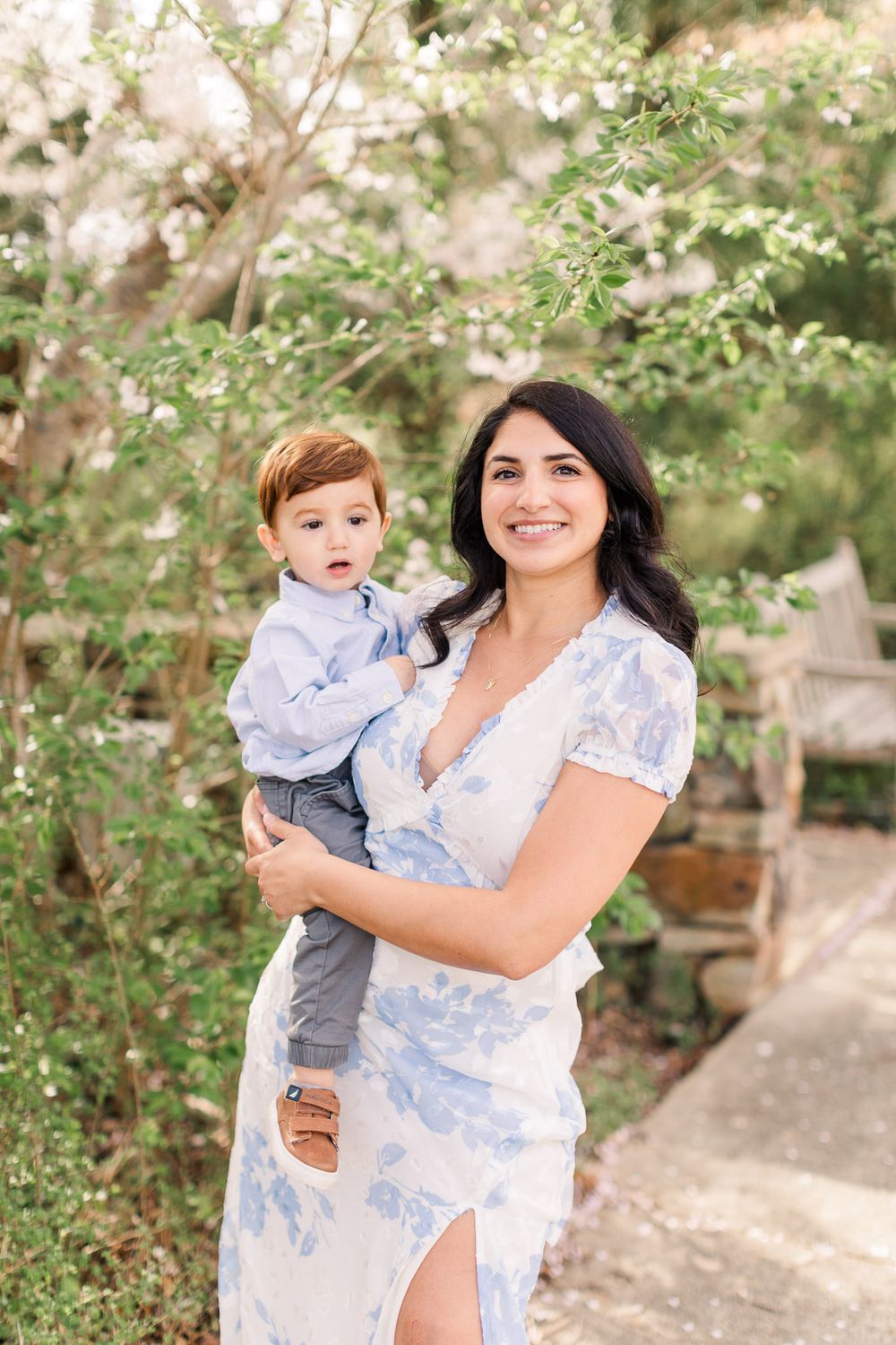 Mom smiling while holding young son during the spring blooms in Richmond Va.