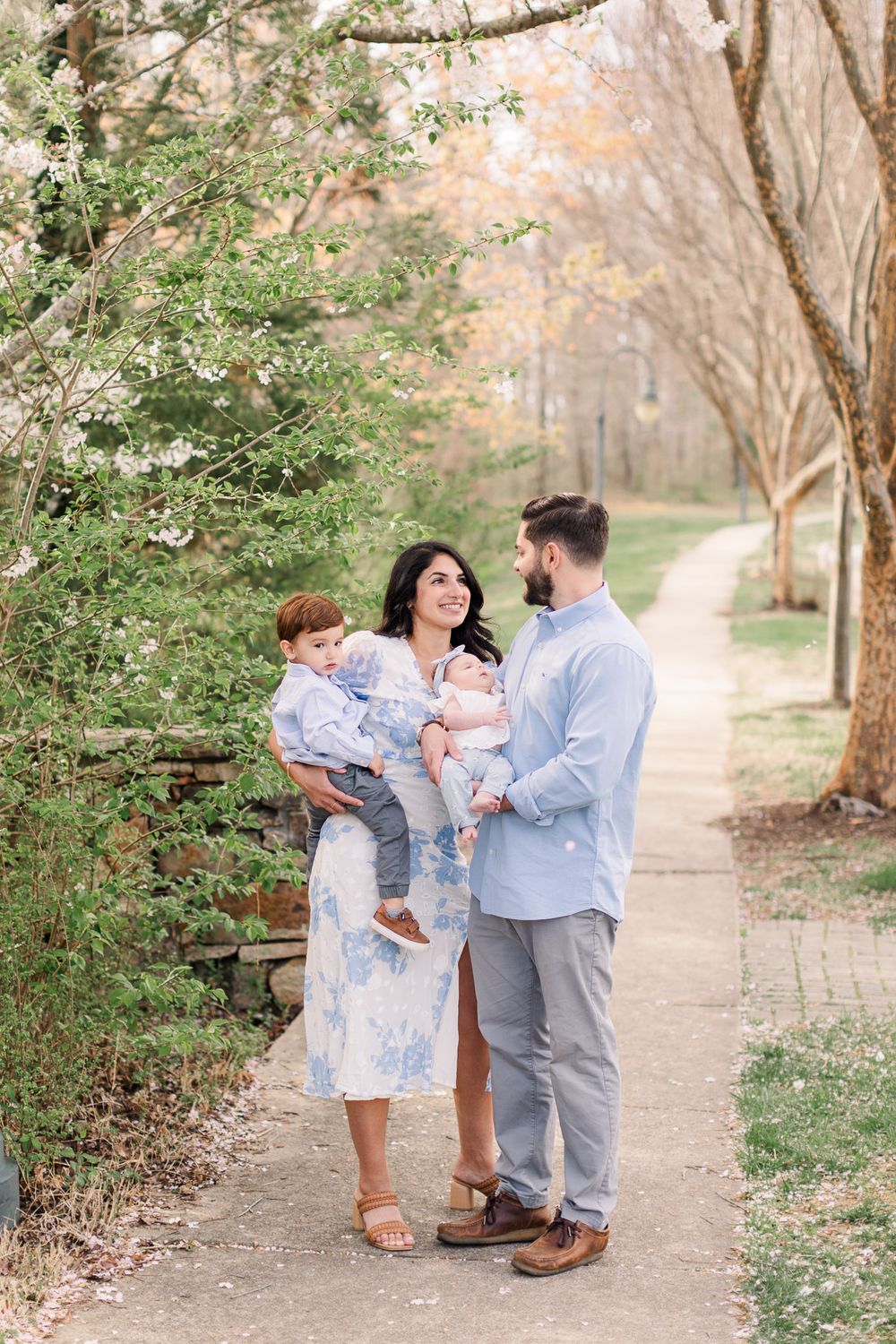 Family smiling together with the Cherry blossoms for a mini photography session in RVA