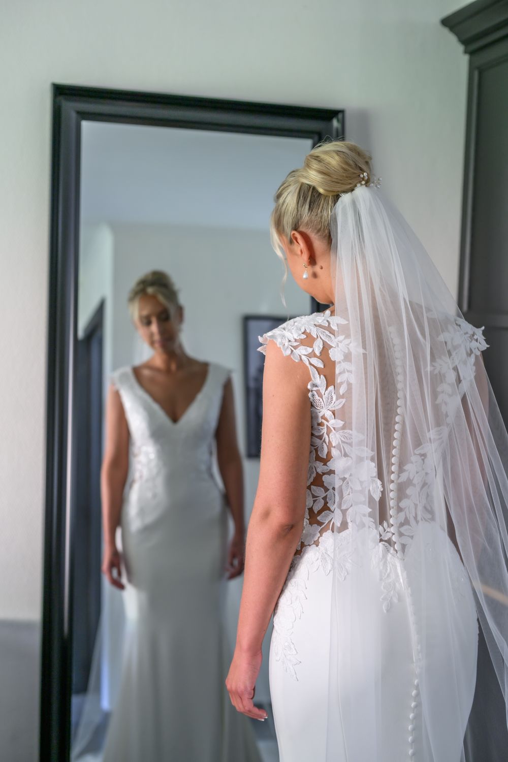 Wedding dress details showing lace back and buttons in getting ready room.