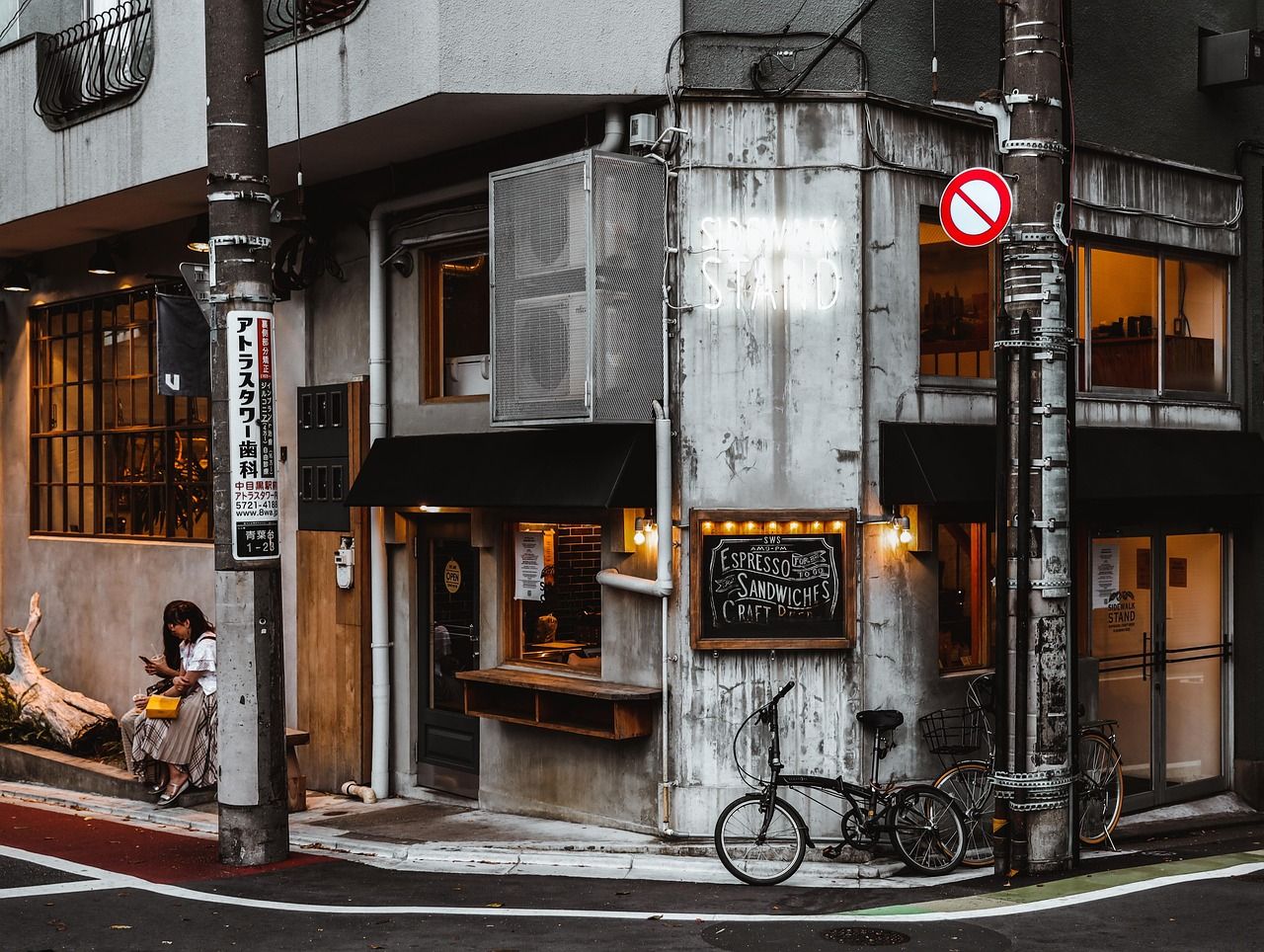 Typical Japan corner street scene with a girl on her cell, signage, architecture and urban life captured on a GETPIX photography tour.