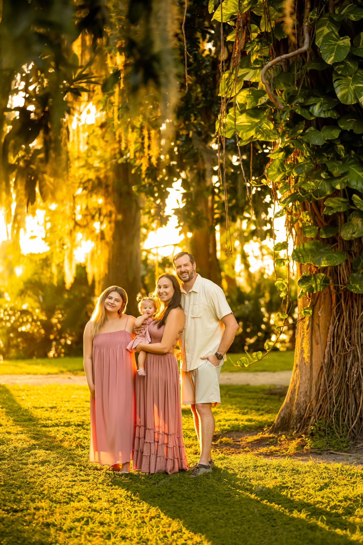 A family walks together under blooming cherry blossom trees in a spring garden setting.