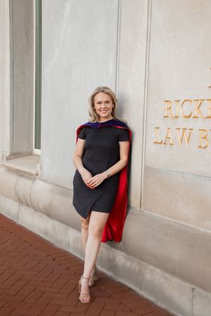 A person in a black dress and red jacket poses against a white wall in a progressive series of candid shots.