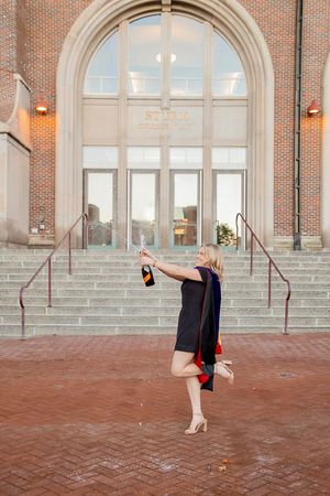 A sequence of five photos showing someone dancing in a black dress against a brick building with arched windows.