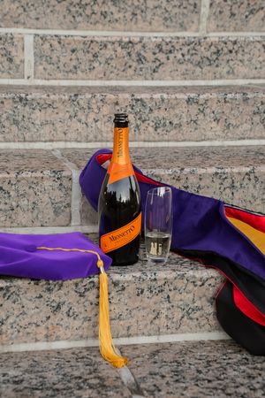A sequence of images showing a champagne bottle being opened with a saber on granite steps.