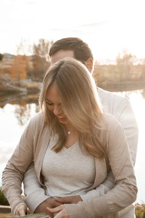 Intimate outdoor photoshoot featuring warm autumn colors and natural lighting beside a serene lake.