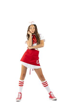 Young woman in red and white cheerleader costume with knee-high socks and red sneakers posing on white background.