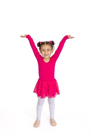 Young dancer in hot pink leotard and tutu poses with arms raised against white background.